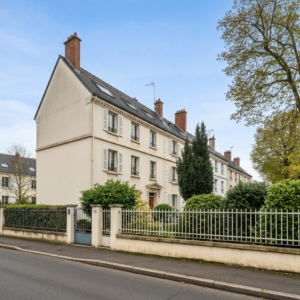 Vue d'un immeuble ancien en cours de rénovation énergétique avec des échafaudages et des panneaux solaires